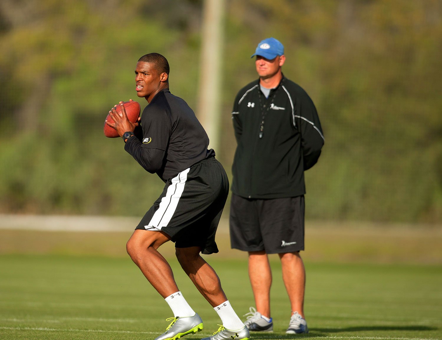 Chris Weinke looks on as Cam Newton throws a pass at the IMG Academy football program Chris Weinke looks on as Cam Newton throws a pass at the IMG Academy football program