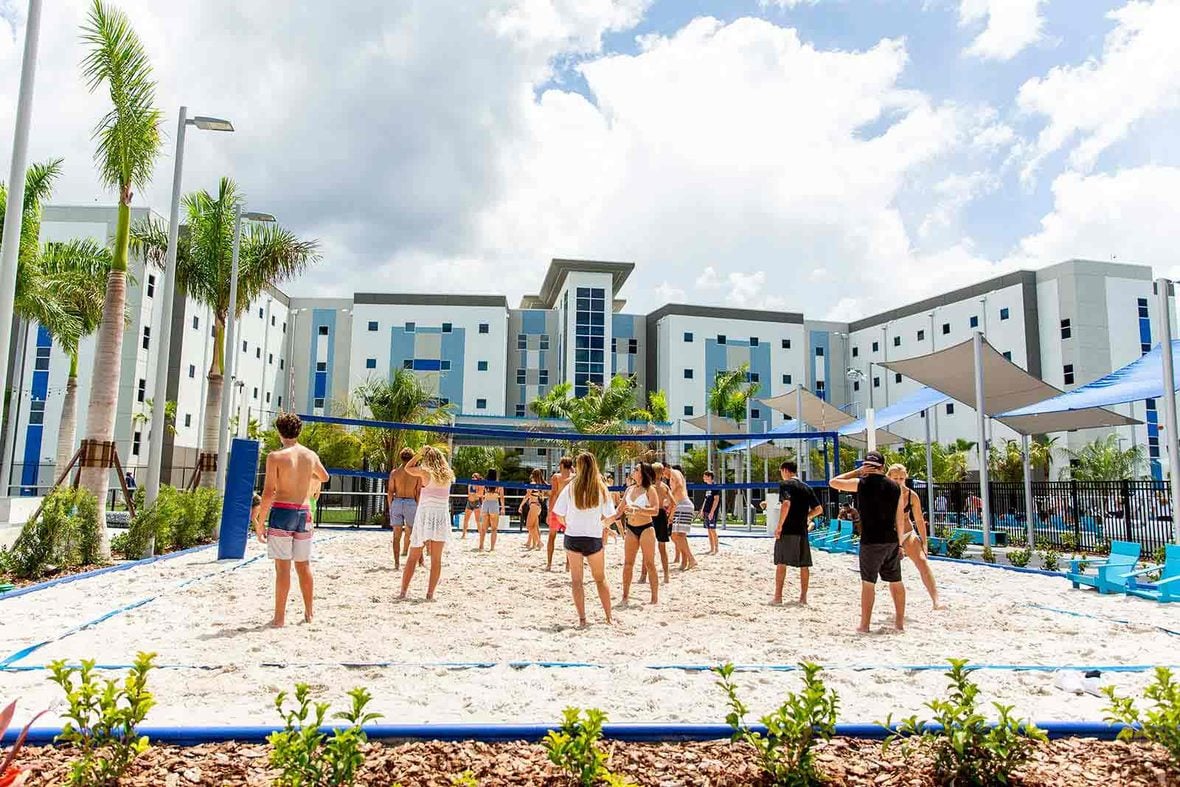 Campers playing beach volleyball beside the IMG Academy residences