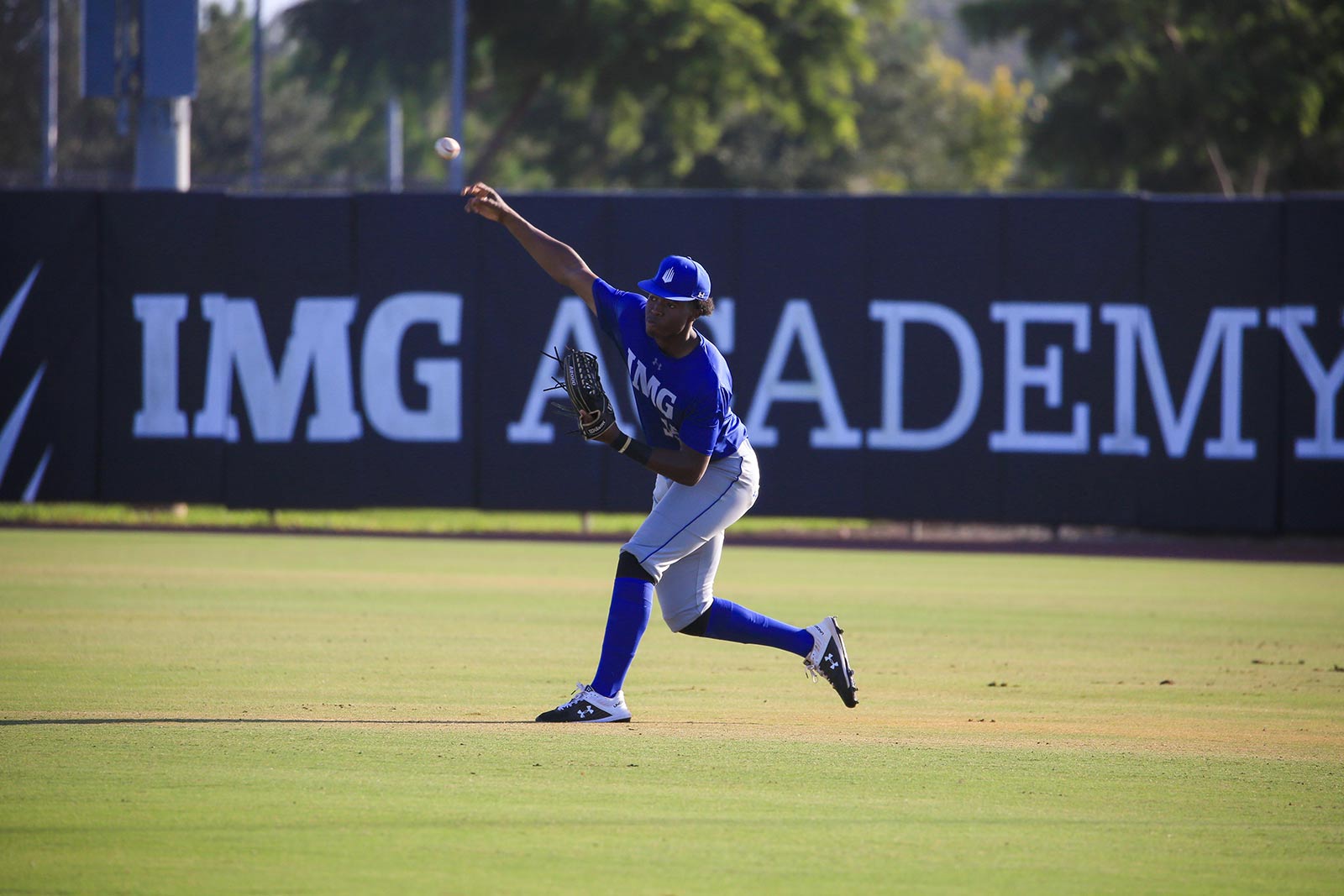 IMG Academy baseball player throws baseball to homeplate from the outfield