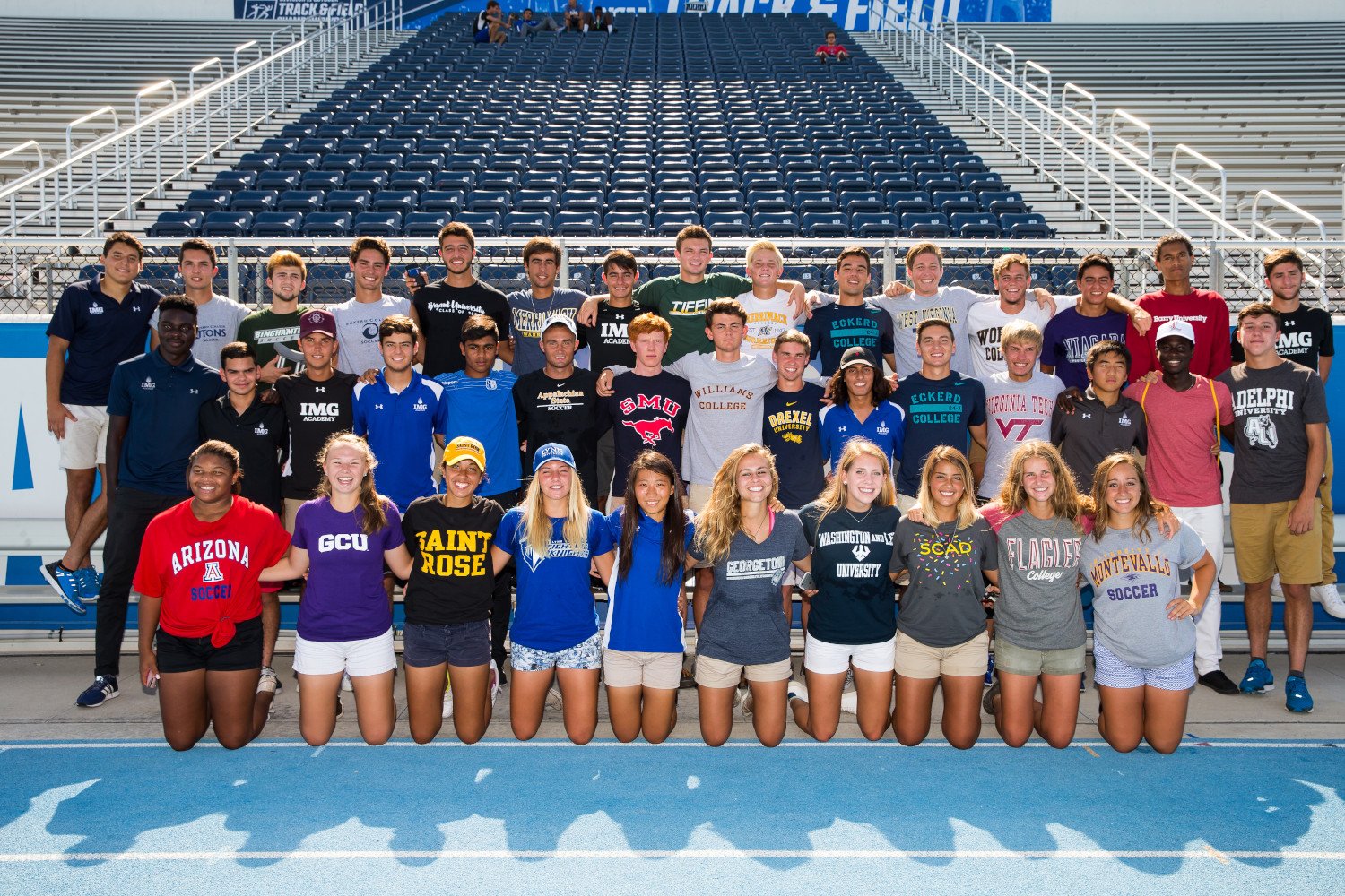 img academy student athletes pose wearing their college shirts at a spring commitment ceremony | IMGAcademy.com