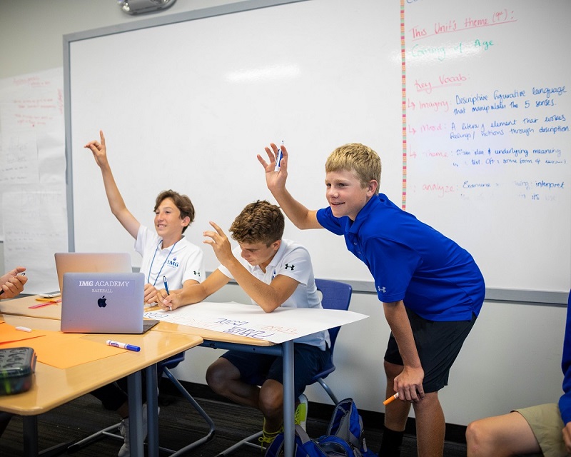 Three Male Students Raise Their Hands in Class | IMGAcademy.com