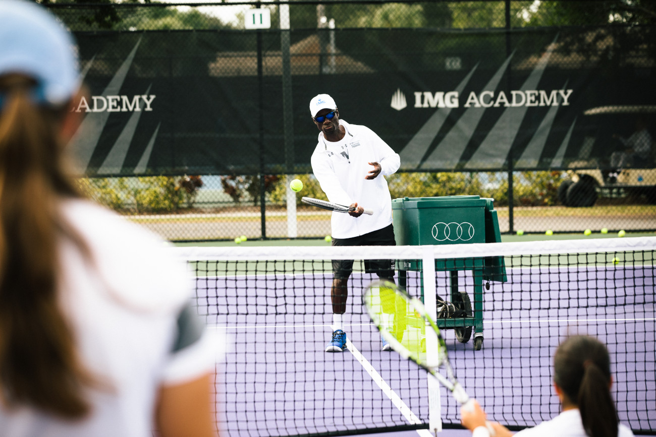 tennis coach works with players at IMG Academy | IMGAcademy.com