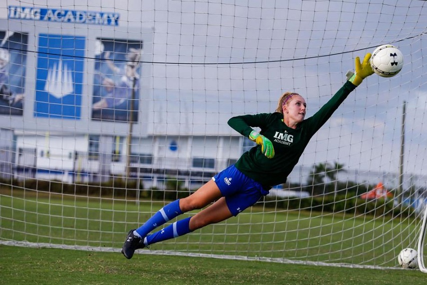 Female soccer goalie dives to make a save