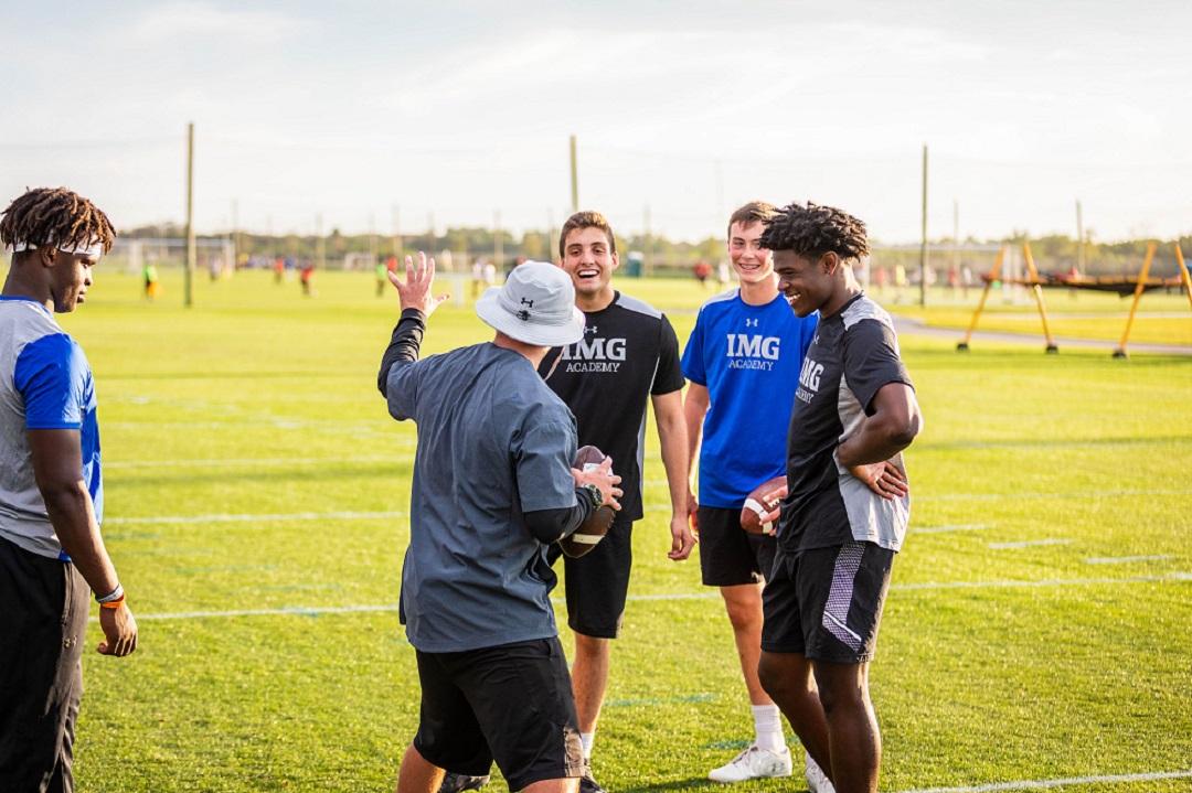 Football players listening to a coach speak in a huddle