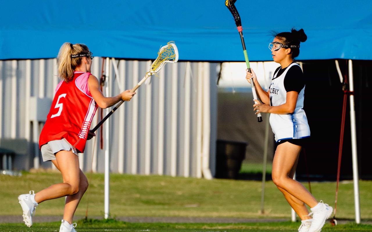 IMG Academy Girls Lacrosse players practicing on a field