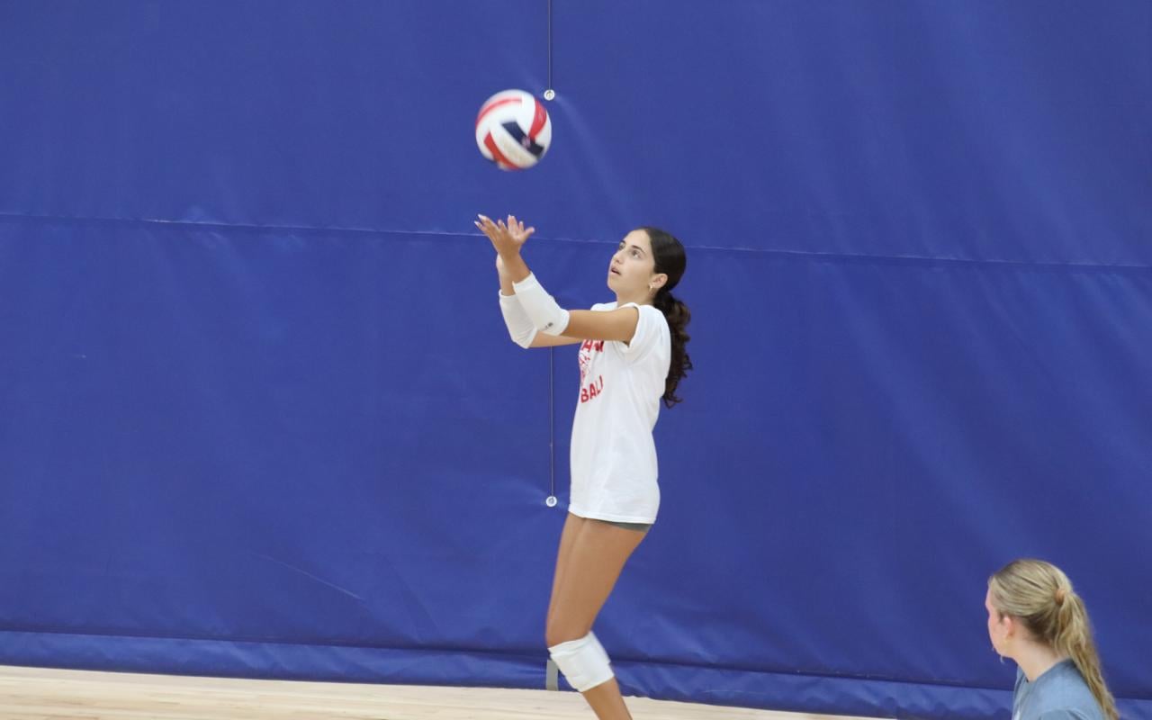 IMG Academy female volleyball player serving the volleyball